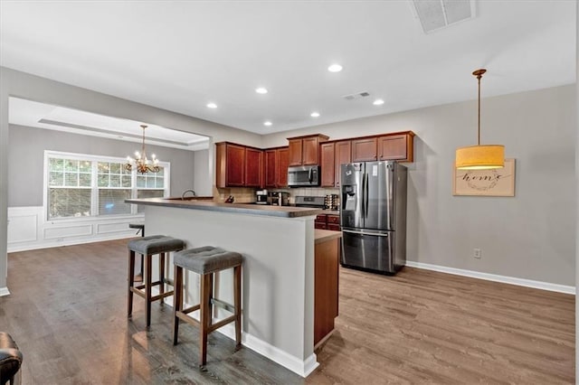 4349 Kousa Rd Unit 4, Austell, GA 30106 - kitchen with stainless steel appliances, a chandelier, a kitchen bar, wood finished floors, and recessed lighting