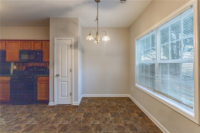 kitchen featuring a healthy amount of sunlight, black appliances, decorative light fixtures, and a notable chandelier