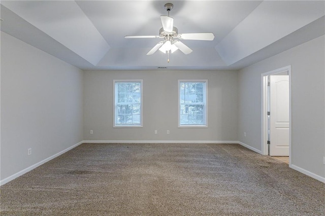 spare room featuring ceiling fan, a raised ceiling, and light carpet