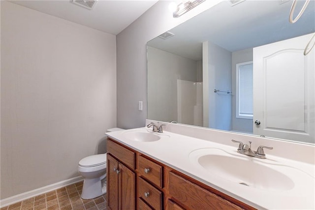 bathroom with vanity, toilet, and a shower