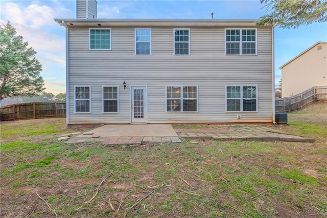 back of property featuring a lawn, central AC unit, and a patio