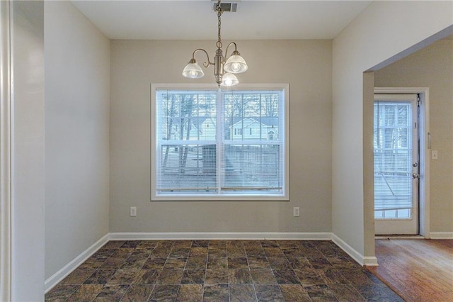 unfurnished dining area with dark hardwood / wood-style flooring and an inviting chandelier