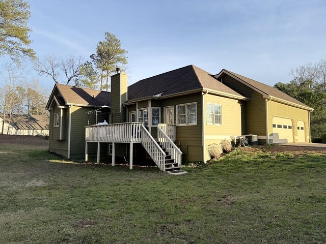 410 Spring Lake Hls, Canton, GA 30114 - back of house featuring stairway, a chimney, an attached garage, central AC unit, and a yard