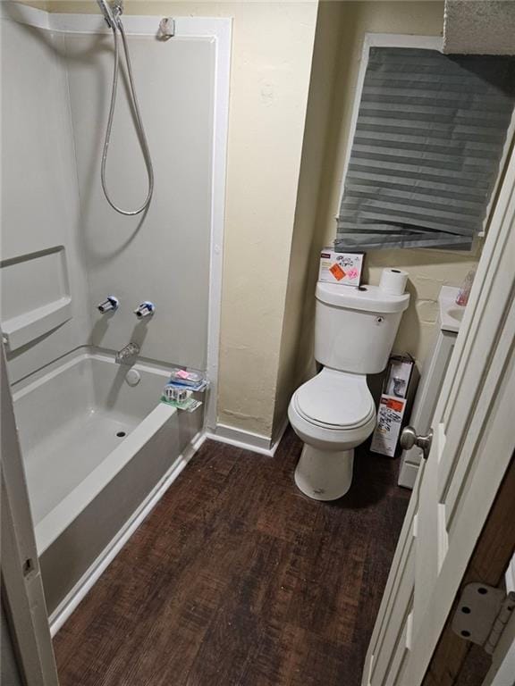 bathroom with hardwood / wood-style flooring, shower / washtub combination, and toilet