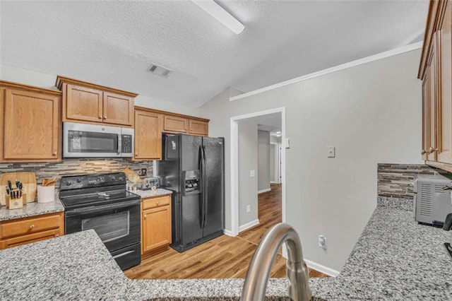 1164 Otis Dr, Bethlehem, GA 30620 - kitchen with black appliances, backsplash, vaulted ceiling, light wood-type flooring, and crown molding