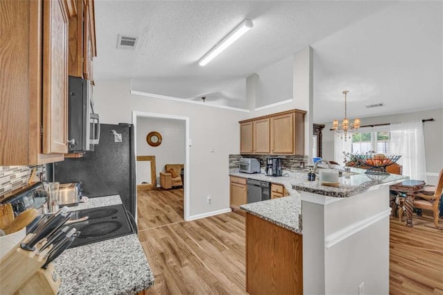 1164 Otis Dr, Bethlehem, GA 30620 - kitchen featuring stainless steel appliances, a peninsula, a chandelier, light wood-type flooring, and vaulted ceiling