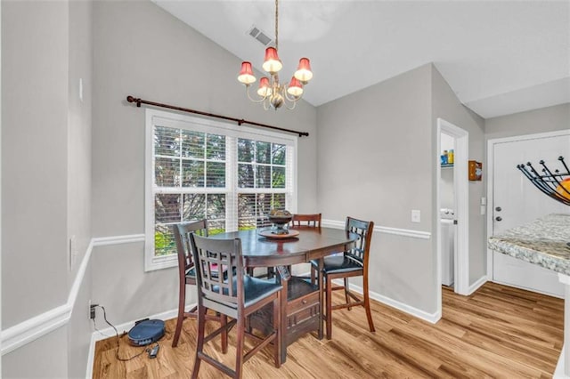 1164 Otis Dr, Bethlehem, GA 30620 - dining room with light wood finished floors, lofted ceiling, a chandelier, and healthy amount of natural light