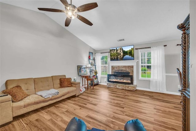 1164 Otis Dr, Bethlehem, GA 30620 - living room with wood finished floors, vaulted ceiling, a ceiling fan, and a stone fireplace
