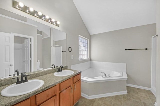 bathroom featuring tile patterned flooring, toilet, vaulted ceiling, a bathing tub, and vanity