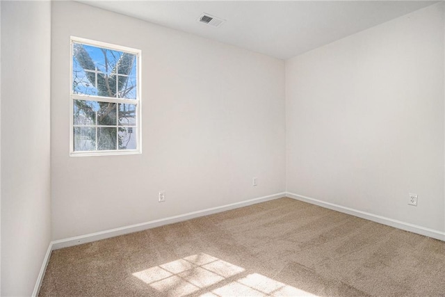 unfurnished room featuring carpet flooring, visible vents, and baseboards