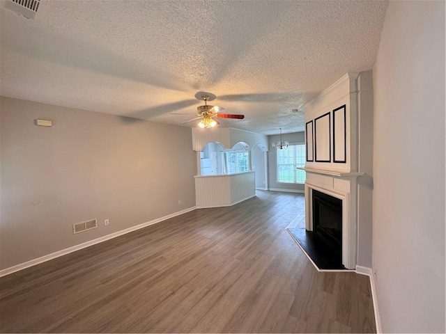 unfurnished living room featuring ceiling fan, wood-type flooring, and a textured ceiling