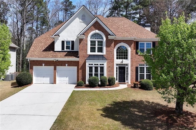 colonial house with brick siding, a front lawn, concrete driveway, roof with shingles, and a garage