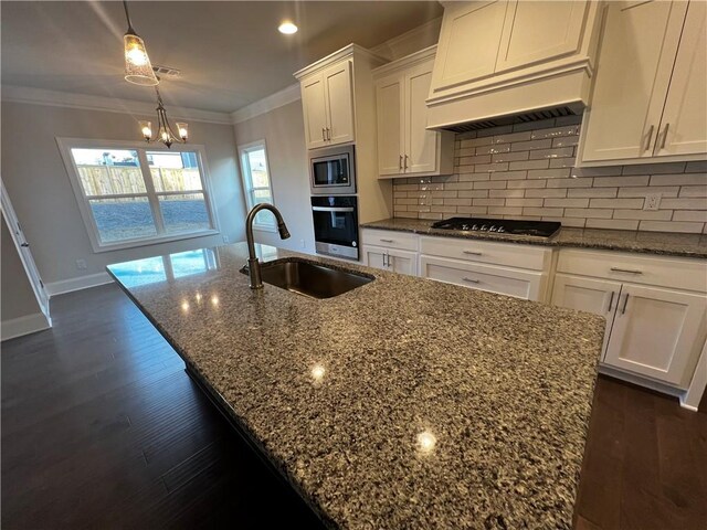 kitchen with an inviting chandelier, dark stone counters, stainless steel appliances, and tasteful backsplash