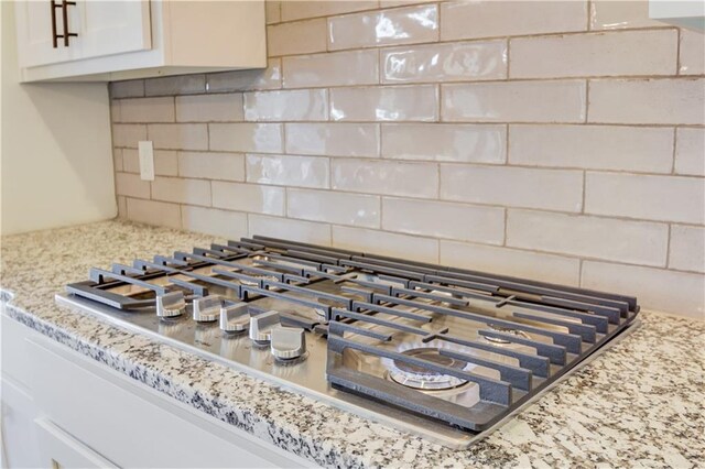 interior details featuring tasteful backsplash and stainless steel gas stovetop