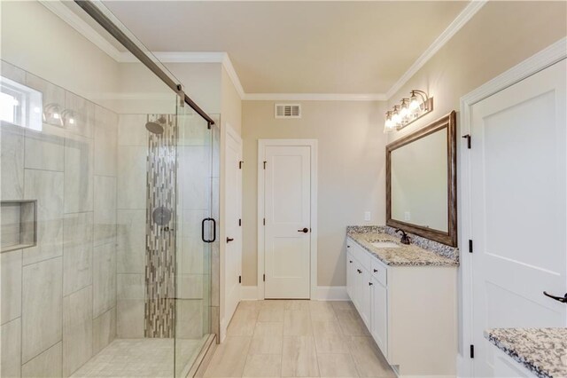 bathroom with a shower with shower door, vanity, tile floors, and ornamental molding