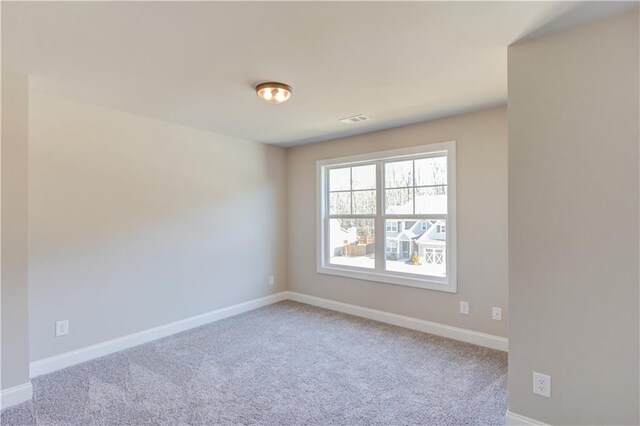 unfurnished room featuring light carpet