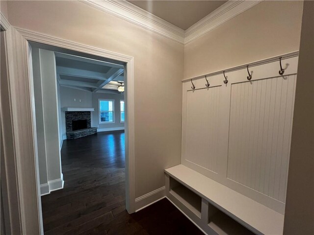 mudroom with coffered ceiling, crown molding, dark hardwood / wood-style floors, a stone fireplace, and ceiling fan