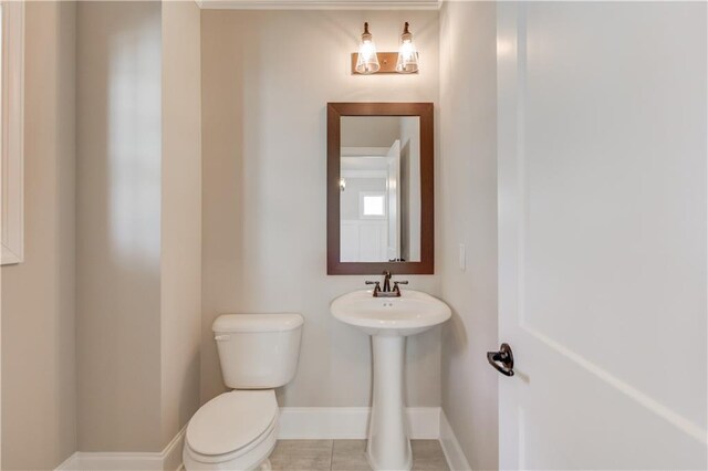 bathroom featuring tile flooring and toilet