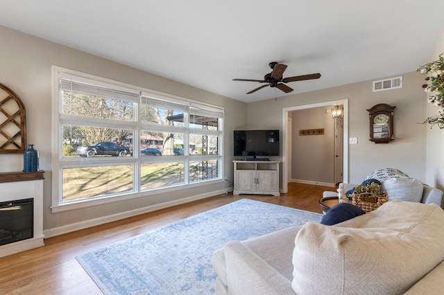 living room with ceiling fan and light hardwood / wood-style floors