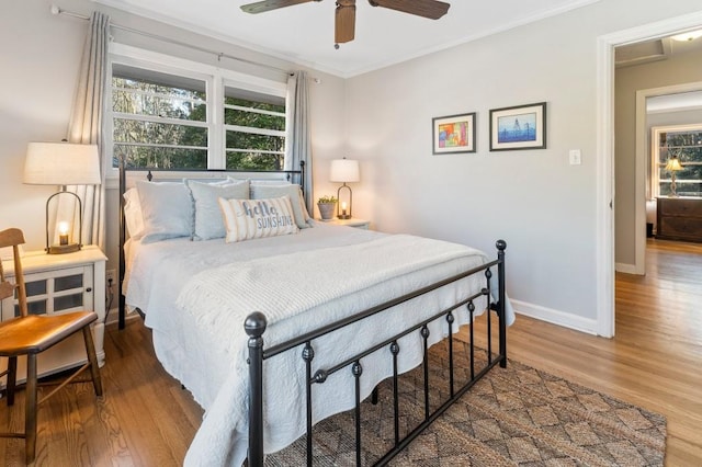 bedroom with hardwood / wood-style flooring, ornamental molding, and ceiling fan