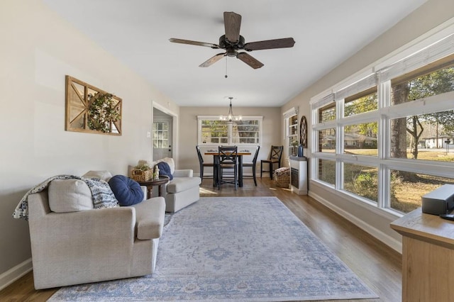 living room featuring dark hardwood / wood-style flooring and ceiling fan with notable chandelier