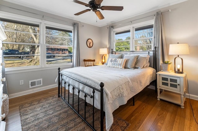 bedroom featuring multiple windows, ornamental molding, and dark wood-type flooring