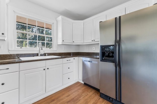 kitchen featuring white cabinetry, appliances with stainless steel finishes, sink, and light hardwood / wood-style floors