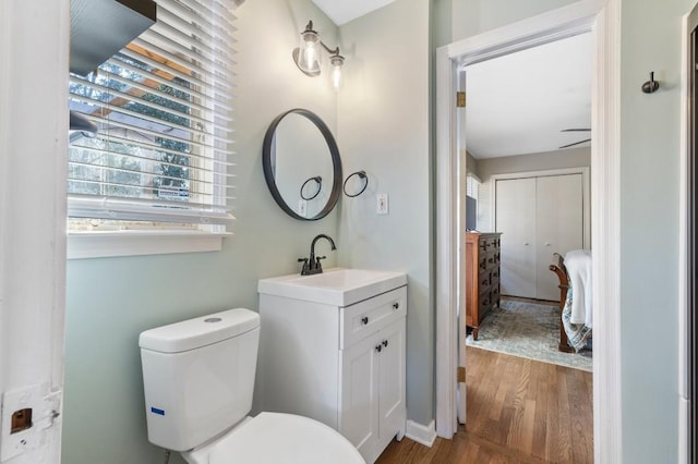 bathroom featuring wood-type flooring, toilet, and vanity