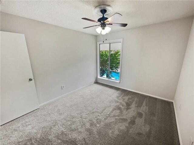 carpeted empty room featuring ceiling fan and a textured ceiling