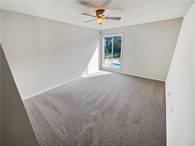 empty room with ceiling fan, carpet, and a textured ceiling