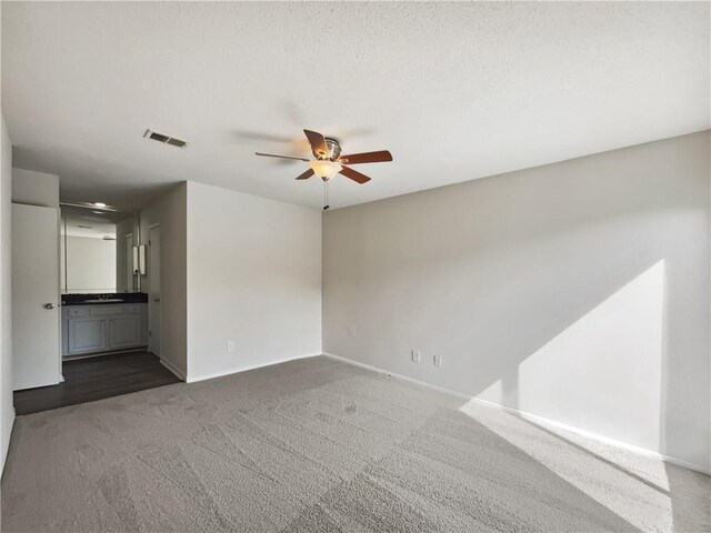 carpeted spare room featuring ceiling fan and a textured ceiling