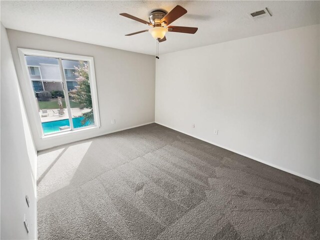 empty room featuring ceiling fan and carpet