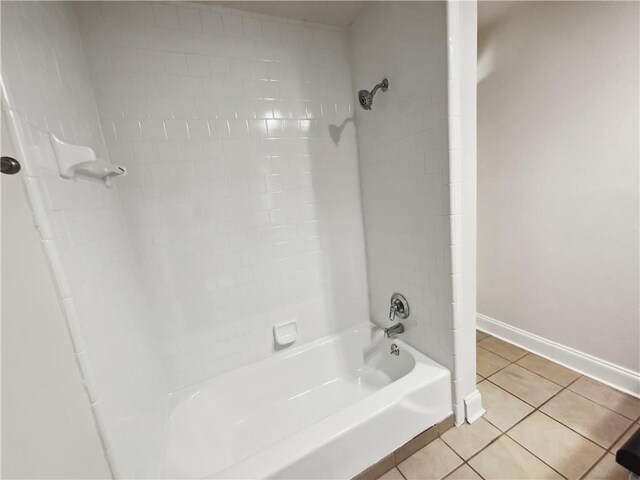 bathroom with tiled shower / bath combo and tile patterned flooring