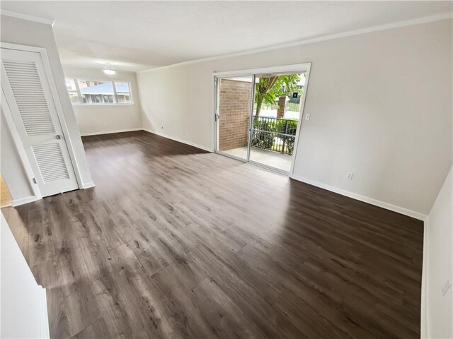 empty room with ornamental molding and dark hardwood / wood-style flooring