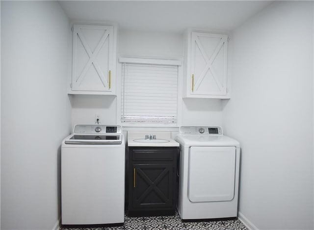 laundry area featuring washer and dryer, cabinets, and sink