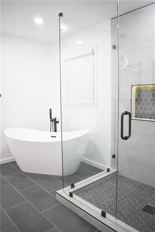 bathroom with tile patterned flooring and shower with separate bathtub