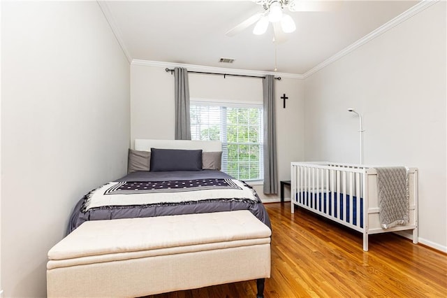 bedroom with ornamental molding, wood finished floors, and ceiling fan