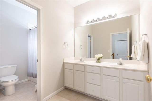 bathroom featuring tile patterned flooring, toilet, double vanity, and baseboards