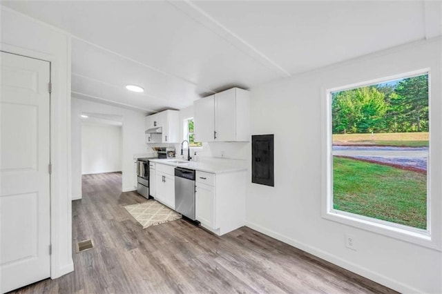 118 Buck Creek Cir, Griffin, GA 30224 - kitchen featuring appliances with stainless steel finishes, electric panel, light countertops, white cabinetry, and wood finished floors