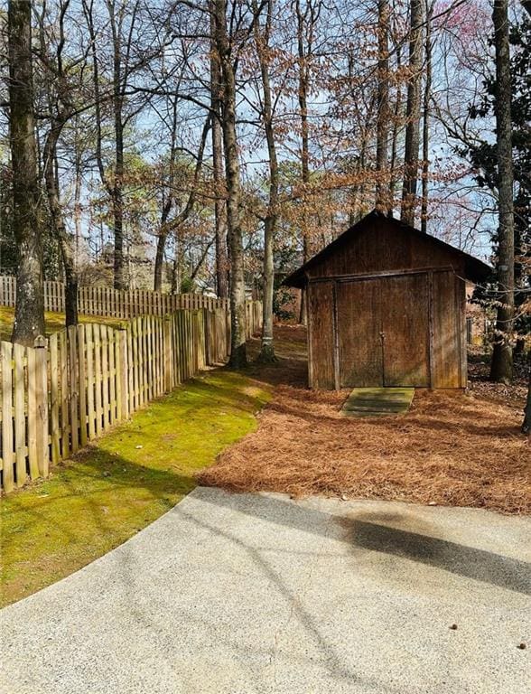 view of yard featuring fence private yard, an outdoor structure, and a storage shed