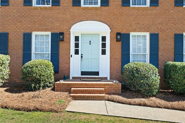 doorway to property with brick siding