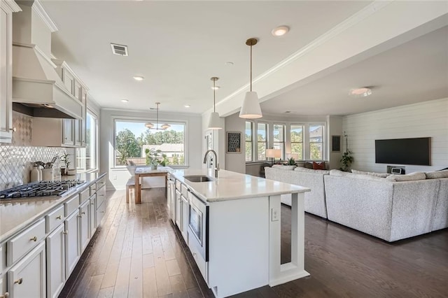 6168 Sweet Birch Ct, Acworth, GA 30101 - kitchen with premium range hood, dark wood finished floors, light countertops, stainless steel gas cooktop, and ornamental molding