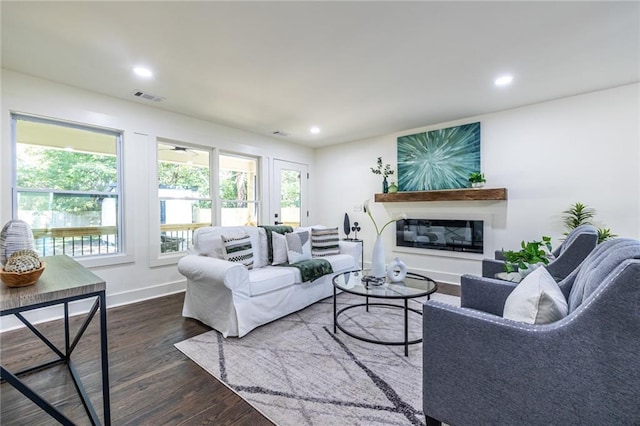 living room with dark wood-type flooring and plenty of natural light