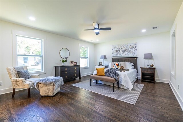 bedroom with a fireplace, dark hardwood / wood-style floors, and ceiling fan