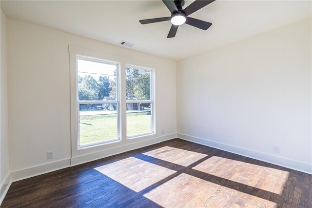 empty room with ceiling fan and dark hardwood / wood-style flooring