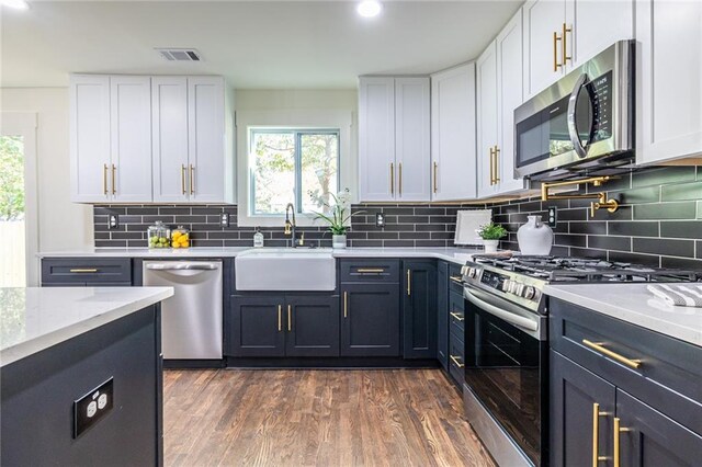 kitchen featuring appliances with stainless steel finishes, white cabinetry, and dark hardwood / wood-style floors