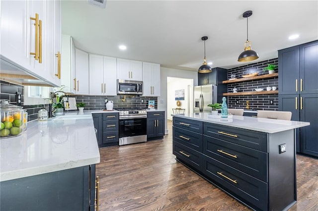 kitchen with a kitchen island, appliances with stainless steel finishes, dark hardwood / wood-style floors, and white cabinets