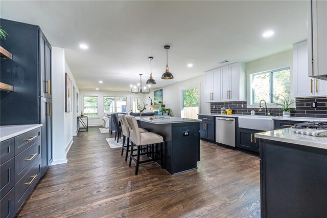 kitchen featuring white cabinetry, a center island, a wealth of natural light, and dishwasher