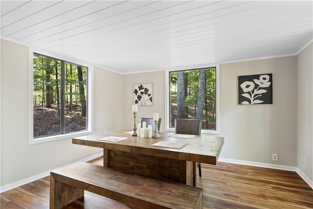 unfurnished dining area featuring wood-type flooring and crown molding