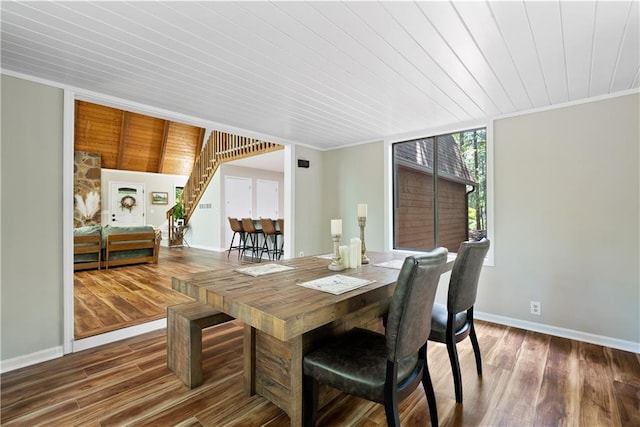 dining space featuring ornamental molding, dark hardwood / wood-style flooring, and wooden ceiling